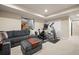 Finished basement with gray sectional, exercise equipment and walkout window at 6780 Canosa St, Denver, CO 80221