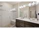 Modern bathroom with double sinks, a glass-enclosed shower with a built-in bench, and contemporary fixtures at 6780 Canosa St, Denver, CO 80221