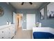 Bedroom with blue walls, white furniture, and a view to the hallway at 6780 Canosa St, Denver, CO 80221