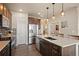 Contemporary kitchen with stainless steel appliances, island seating, and dark wood cabinetry at 6780 Canosa St, Denver, CO 80221