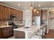 A modern eat-in kitchen with stainless steel appliances, island with barstool seating, and pendant lighting at 6780 Canosa St, Denver, CO 80221