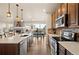 Modern kitchen features stainless steel appliances, an island with seating, and a view into the connected living room at 6780 Canosa St, Denver, CO 80221