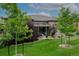 Landscaped yard with covered patio featuring colorful foliage and trees, showcasing a peaceful retreat at 3418 New Haven Cir, Castle Rock, CO 80109