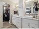 Bright bathroom featuring double sinks, vanity storage, and a peek into the walk-in closet at 8983 W Capri Ave, Littleton, CO 80123