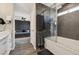 En-suite bathroom showcasing modern shower/tub with glass doors and a glimpse into the main bedroom at 8983 W Capri Ave, Littleton, CO 80123