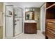 Bathroom featuring a glass-enclosed shower and vanity with dark wood cabinets providing storage space at 8983 W Capri Ave, Littleton, CO 80123