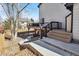 Wooden deck with black railings and a staircase leading to the backyard, enhanced by stone landscaping at 8983 W Capri Ave, Littleton, CO 80123