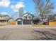 Traditional two-story home with a three-car garage and neutral colored exterior at 8983 W Capri Ave, Littleton, CO 80123