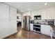 Well-lit kitchen featuring stainless steel appliances and white cabinets, offering a modern and clean design at 8983 W Capri Ave, Littleton, CO 80123