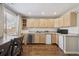 Charming kitchen with wooden cabinets, stainless steel appliances, and hardwood flooring at 8983 W Capri Ave, Littleton, CO 80123