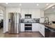 Bright kitchen with stainless steel refrigerator, oven, dark countertops, and white cabinetry, creating a modern feel at 8983 W Capri Ave, Littleton, CO 80123