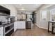 Contemporary kitchen featuring stainless steel appliances, black countertops, with an open layout at 8983 W Capri Ave, Littleton, CO 80123