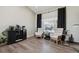 Cozy living area features a dark cabinet and neutral-toned armchairs under large windows at 8983 W Capri Ave, Littleton, CO 80123