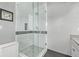 Modern bathroom features a glass-enclosed shower with gray mosaic tile accent and gray flooring at 4548 E Kentucky Cir, Denver, CO 80246