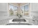 Bright kitchen sink featuring granite counters, subway tile backsplash, stainless steel faucet, and corner window at 4548 E Kentucky Cir, Denver, CO 80246