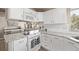 Kitchen with white cabinets, granite counters, subway tile, and stainless steel appliances with eat-in breakfast nook at 4548 E Kentucky Cir, Denver, CO 80246