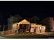 Night view of a charming two-story home with a covered porch and three-car garage at 12405 E 101St Dr, Commerce City, CO 80022