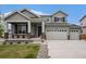 Charming two-story home with a covered porch, three-car garage and landscaped front yard at 12405 E 101St Dr, Commerce City, CO 80022