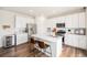 Modern kitchen with white cabinets, stainless steel appliances, and a spacious island with seating at 12405 E 101St Dr, Commerce City, CO 80022