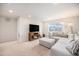 Bright living room featuring a plush sectional, modern fireplace, and a large window offering natural light at 12405 E 101St Dr, Commerce City, CO 80022
