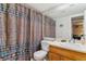 Bathroom featuring a toilet, sink with a wooden vanity, and a colorful patterned shower curtain at 3320 S Ammons St # 104, Lakewood, CO 80227