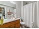 Functional bathroom features a sink, toilet, and a shower with a white curtain at 3320 S Ammons St # 104, Lakewood, CO 80227