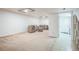 Open finished basement with tiled flooring, comfortable seating, and an open doorway at 1063 W Powers Ave, Littleton, CO 80120