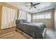 Bedroom with ceiling fan and large window; wood frame bed with gray comforter at 1063 W Powers Ave, Littleton, CO 80120