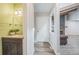 Hallway view of bathroom, entryway, and partial view of living room with stone fireplace at 1063 W Powers Ave, Littleton, CO 80120