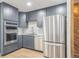 Modern kitchen features stainless steel appliances, gray cabinetry, built-in oven and hardwood floors at 1063 W Powers Ave, Littleton, CO 80120
