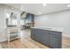 Well-lit kitchen with gray island adjacent to living room with fireplace and exposed beams at 1063 W Powers Ave, Littleton, CO 80120