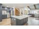 Modern kitchen boasts stainless steel appliances, gray cabinetry, and a spacious island with granite countertop at 1063 W Powers Ave, Littleton, CO 80120