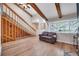 Bright living room features vaulted ceilings, exposed beams, hardwood floors, and a cozy couch by the window at 1063 W Powers Ave, Littleton, CO 80120