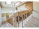 Carpeted staircase with wood railing offers views of the home's spacious living area at 1063 W Powers Ave, Littleton, CO 80120