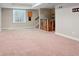 A spacious carpeted basement with a unique wood bar area and staircase at 6735 Avrum Dr, Denver, CO 80221