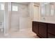 The stylish bathroom features sleek white tile in the shower, a dark wood vanity, and a bright, clean aesthetic at 6735 Avrum Dr, Denver, CO 80221