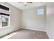 A bright bedroom with two windows and carpet floors, featuring a ceiling fan at 6735 Avrum Dr, Denver, CO 80221