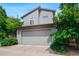 Exterior view of a two-story house with gray siding and a two-car garage at 6735 Avrum Dr, Denver, CO 80221