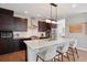 Kitchen featuring a large island, stainless steel appliances, and dark wood cabinetry at 6735 Avrum Dr, Denver, CO 80221