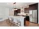 Well-appointed kitchen featuring a large island, stainless steel appliances, and dark wood cabinetry at 6735 Avrum Dr, Denver, CO 80221