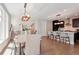Open concept kitchen with modern lighting, stainless appliances, and island seating at 6735 Avrum Dr, Denver, CO 80221