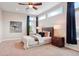 This main bedroom features an eye-catching ceiling fan, a large bed, and plenty of natural light from the big windows at 6735 Avrum Dr, Denver, CO 80221