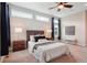 This main bedroom features an eye-catching ceiling fan, a large bed, and plenty of natural light from the big windows at 6735 Avrum Dr, Denver, CO 80221