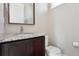 This powder room features a granite countertop, dark wood vanity, and neutral walls, offering a stylish and functional space at 6735 Avrum Dr, Denver, CO 80221