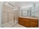 Bathroom featuring a shower, glass door, and wooden vanity, offering a clean and functional space at 235 S Monaco Pkwy, Denver, CO 80224