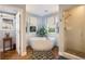 Bright bathroom featuring soaking tub, walk-in shower, gray accents, and dual pane windows at 3002 S Oak Way, Lakewood, CO 80227