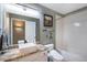 Bathroom features an updated vanity, neutral walls, a framed mirror, and a shower-tub combo at 3002 S Oak Way, Lakewood, CO 80227
