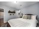 Comfortable bedroom featuring plush bedding and pillows, neutral decor, and hardwood flooring at 3002 S Oak Way, Lakewood, CO 80227