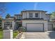 Charming two-story stucco home featuring a manicured lawn and an attached two-car garage at 3002 S Oak Way, Lakewood, CO 80227