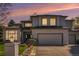 Charming two-story stucco home featuring a manicured lawn and an attached two-car garage during sunset at 3002 S Oak Way, Lakewood, CO 80227